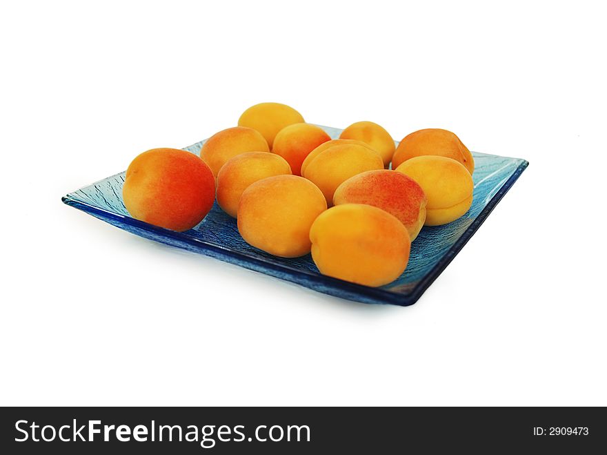 Sweet appricots on the blue glass plate