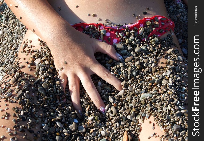 The sexual girl in a pebble on a beach