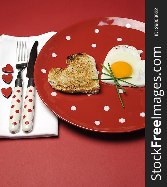 Red theme Valentine breakfast with heart shape egg and toast with love hearts on red background. Red theme Valentine breakfast with heart shape egg and toast with love hearts on red background.