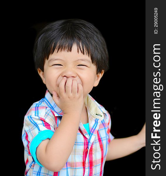 Little boy laughing with one hand in front of his mouth