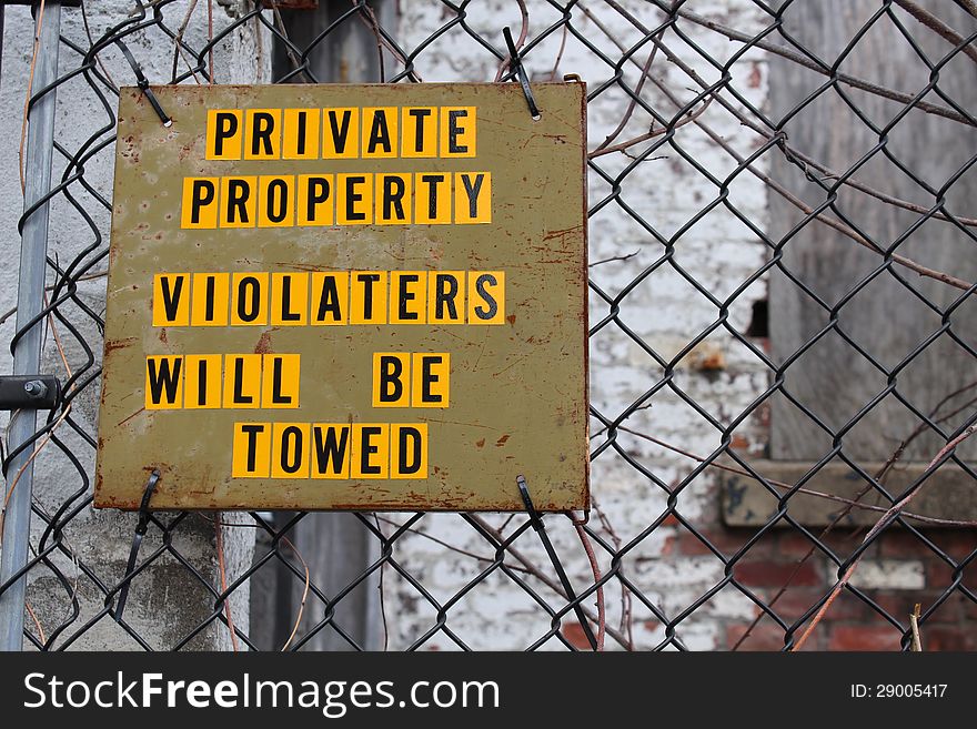 Handmade sign on simple wood in bright yellow and black letters stating private property. Handmade sign on simple wood in bright yellow and black letters stating private property.