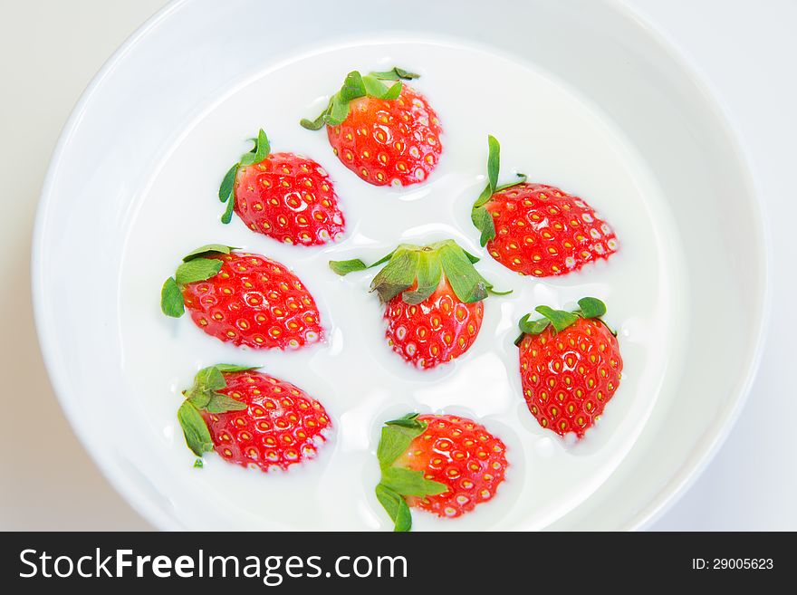 Fresh strawberry in fresh milk in white bowl