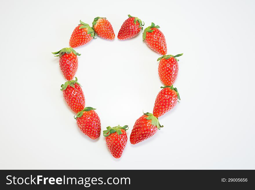 Fresh strawberry in heart shape on white background