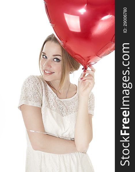 Beautiful woman holding red heart balloon over white background.