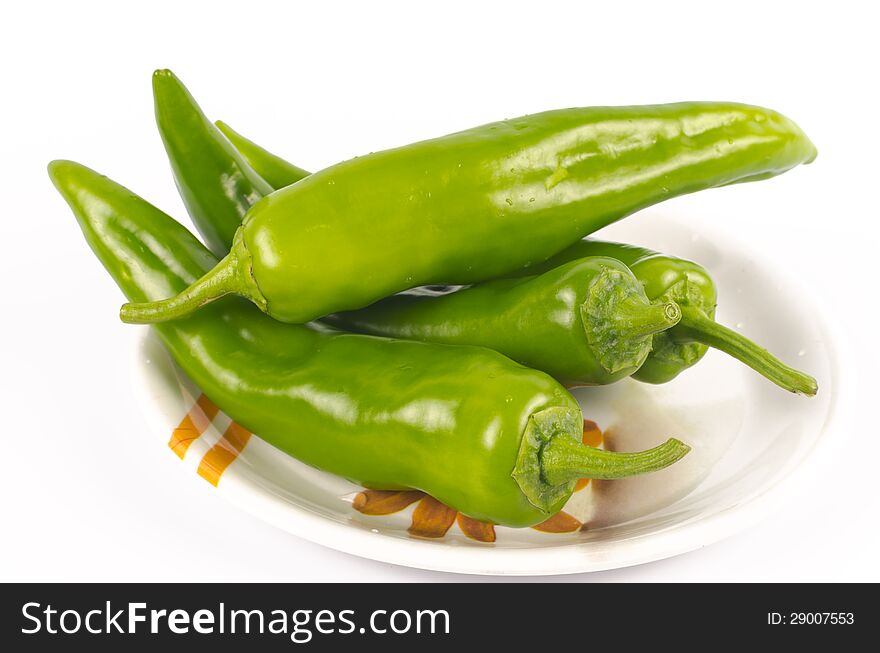 Green chilli peppers (Jalapenos) placed in a saucer on white background. Green chilli peppers (Jalapenos) placed in a saucer on white background.