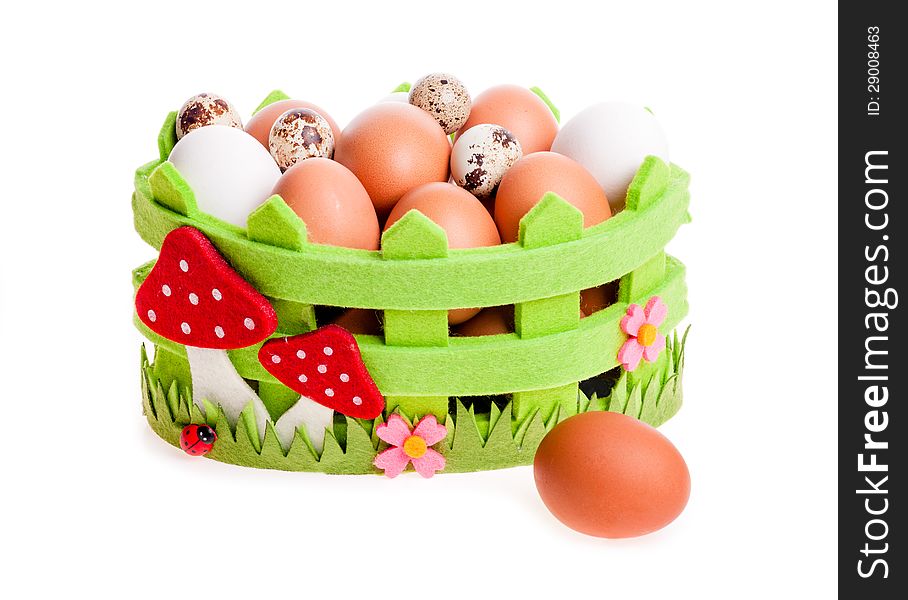 Quail eggs and chicken in green decorative basket on the white