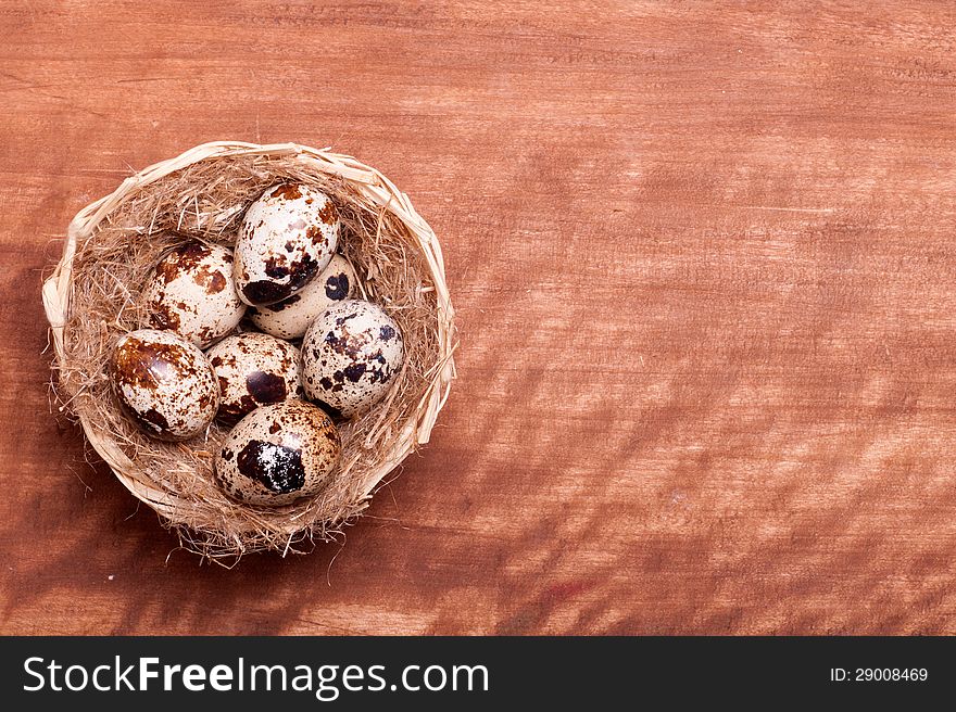 Quail eggs in the nest of a view from the top of the wooden background