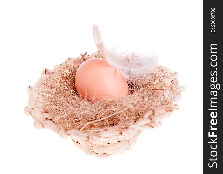 Yellow of the egg with a feather in a straw hat isolated