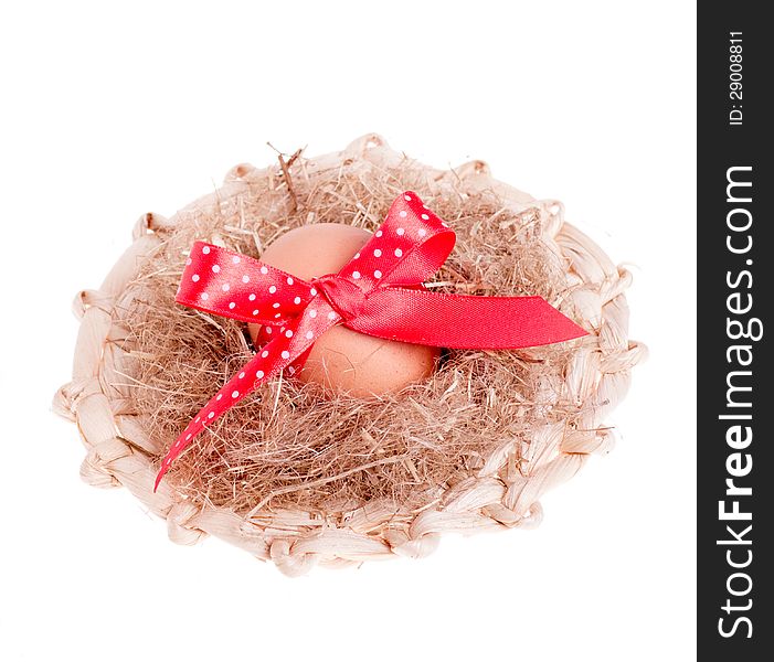 Easter egg with a red ribbon in the straw hat isolated