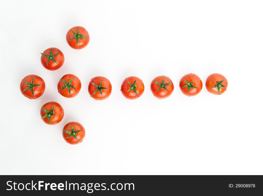 Arrow made of tomatoes over white background. Arrow made of tomatoes over white background