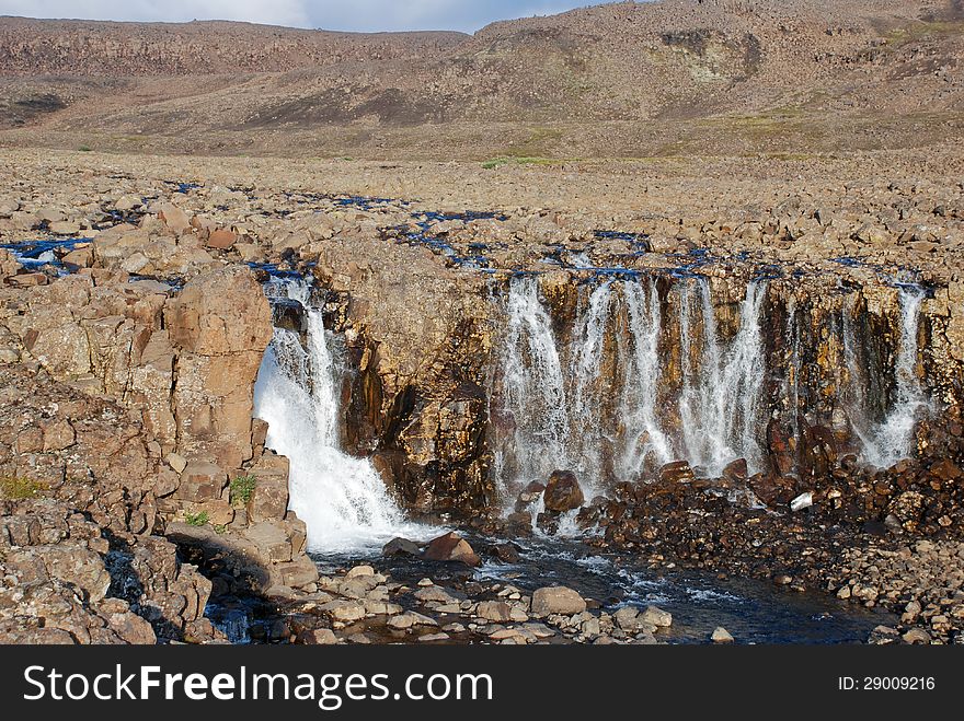 A rocky landscape with a waterfall.