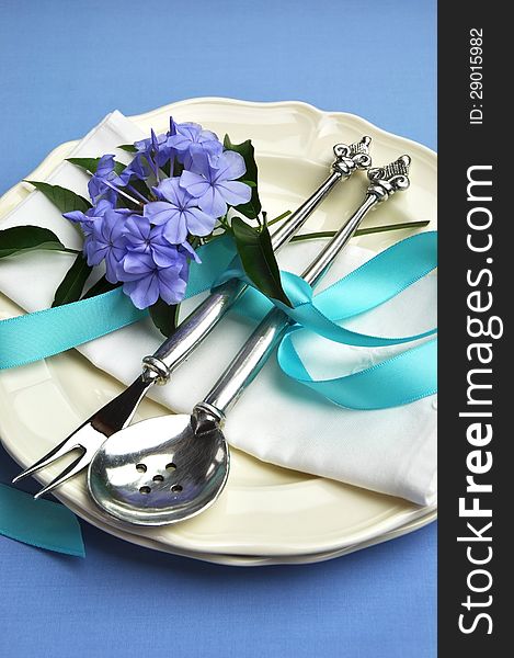 Beautiful silver cutlery, plates and serviette napkins for a modern twist on traditional table setting elegance. Blue theme for Easter or special occasion - vertical. Beautiful silver cutlery, plates and serviette napkins for a modern twist on traditional table setting elegance. Blue theme for Easter or special occasion - vertical.