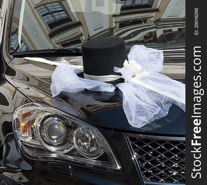 Detail of a hat and bow decoration on a black wedding car. Detail of a hat and bow decoration on a black wedding car.