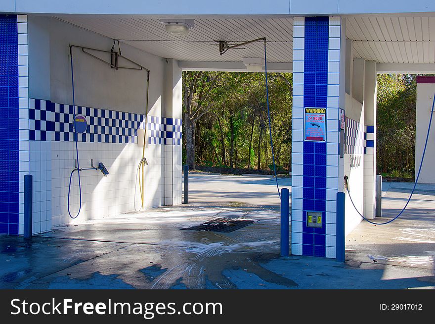 Empty self serve carwash with brushes and sprayers. Empty self serve carwash with brushes and sprayers