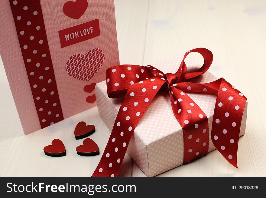 Love theme ft card with pink gift and red polka dot ribbon and hearts.