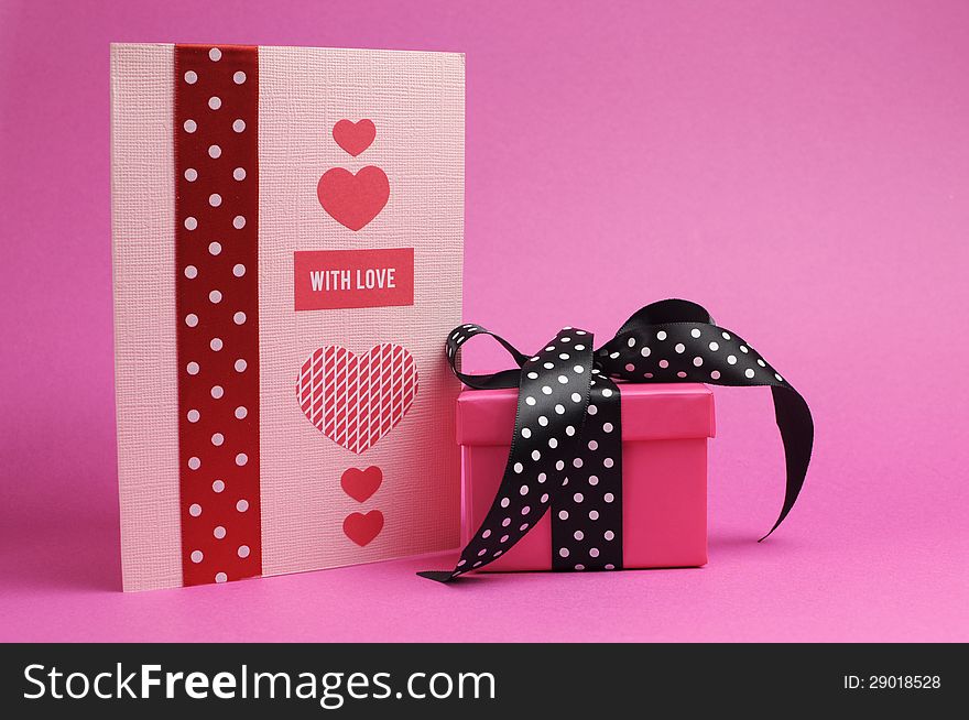 Cute handmade pink and red greeting cardand gift with polka dot ribbon and 'with love' message on a pink background. Cute handmade pink and red greeting cardand gift with polka dot ribbon and 'with love' message on a pink background.