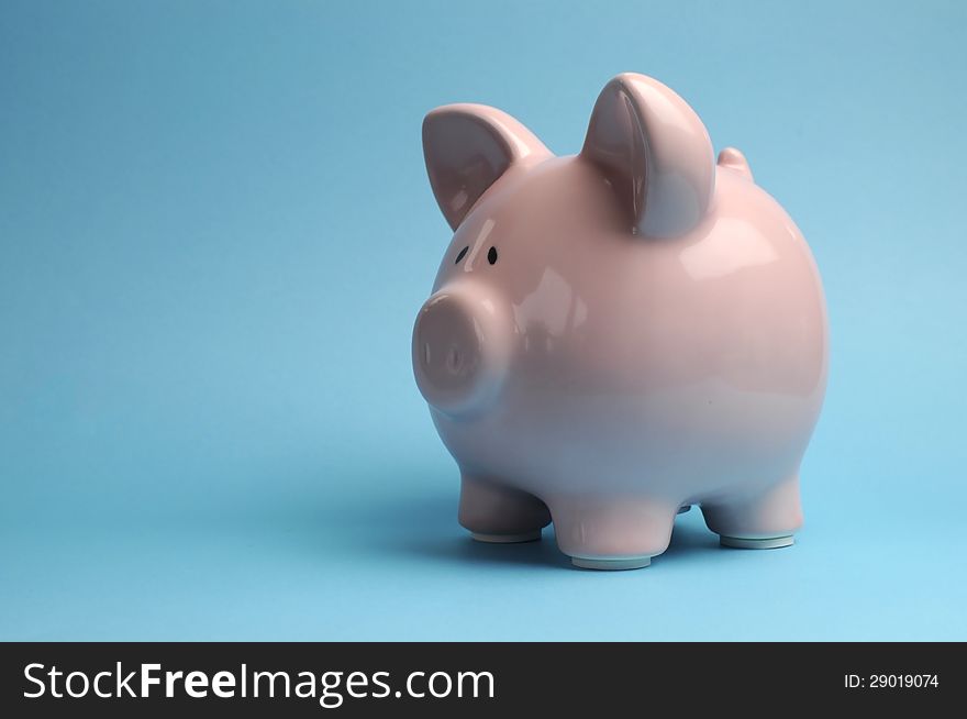 Pretty pink piggy bank against a blue background