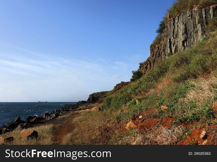 A cliff made of basaltic rocks on the oceanside. Photo taken in Senegal. A cliff made of basaltic rocks on the oceanside. Photo taken in Senegal.