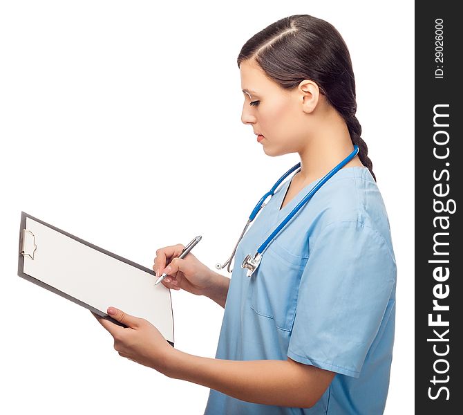 Serious young female doctor writing on clipboard