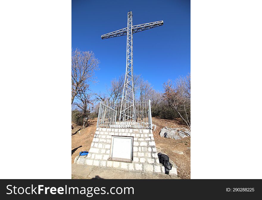 Christian cross on a mound against a blue sky with white clouds. Christian symbol. Religion and culture. Ukrainian Orthodox Church