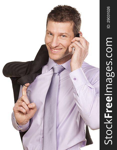 Smiling businessman with a jacket over his shoulder telephones on white background. Smiling businessman with a jacket over his shoulder telephones on white background