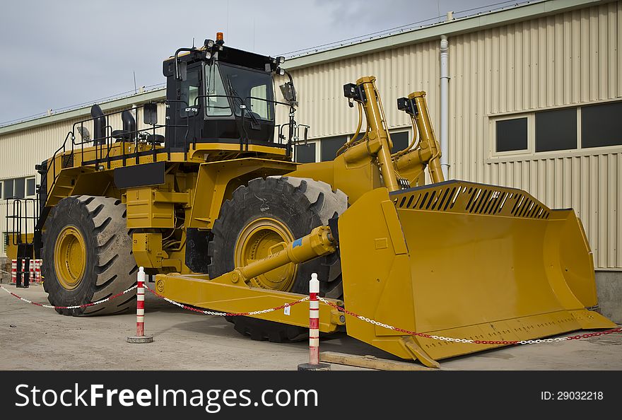 A lately assembled wheel loader is parking in front of a warehouse