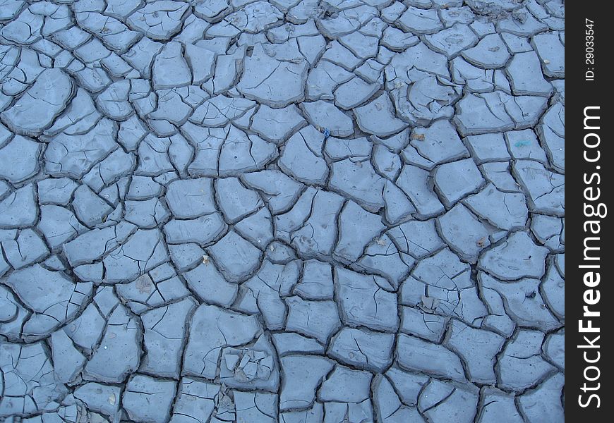 Dry cracked blue clay surface background