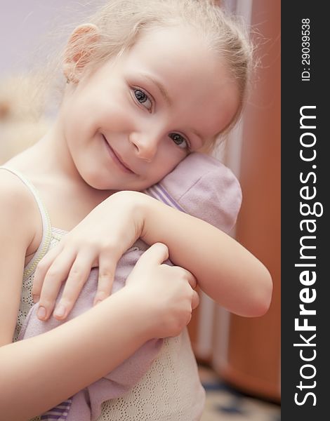 Portrait of happy little smiling girl holding toy shot indoors. Portrait of happy little smiling girl holding toy shot indoors