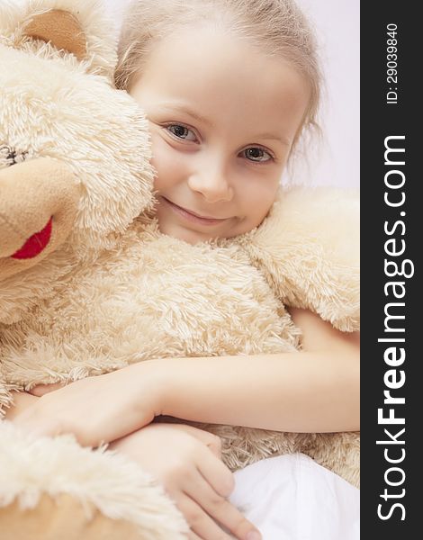 Cute portrait of little girl smiling sitting embracing teddy-bear. Cute portrait of little girl smiling sitting embracing teddy-bear