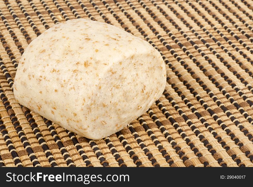 One steamed whole wheat bun on a place mat. One steamed whole wheat bun on a place mat.