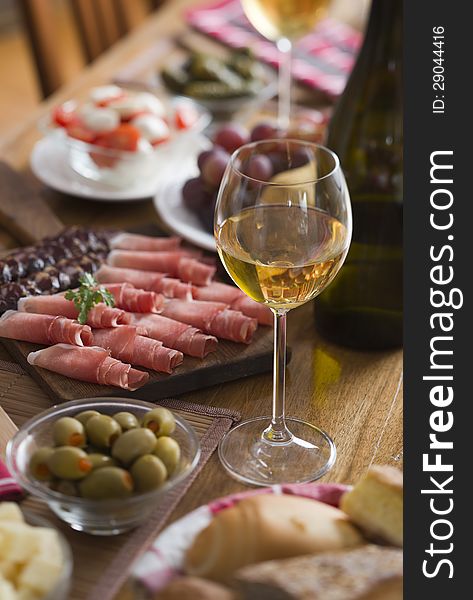 Glass of white wine on a table full with food