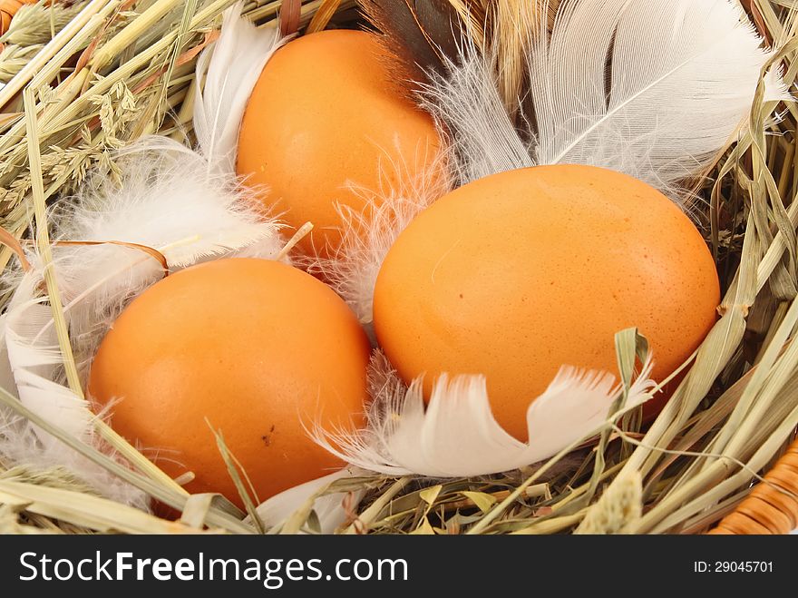 Brown eggs in wooden basket with hay and feather, food ingredient photo. Brown eggs in wooden basket with hay and feather, food ingredient photo