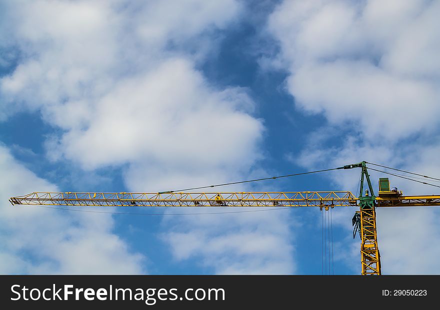 A construction crane with cloudy blue sky