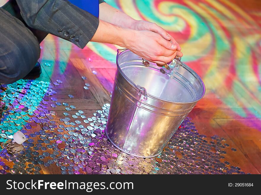 Coins on the floor being thrown into a bucket. Coins on the floor being thrown into a bucket.