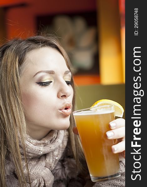Portrait of a young woman with beautiful blue eyes drinking a pint of hefeweizen beer. Portrait of a young woman with beautiful blue eyes drinking a pint of hefeweizen beer.