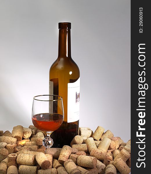 A Glass Of Wine, A Bottle, And Many Corks