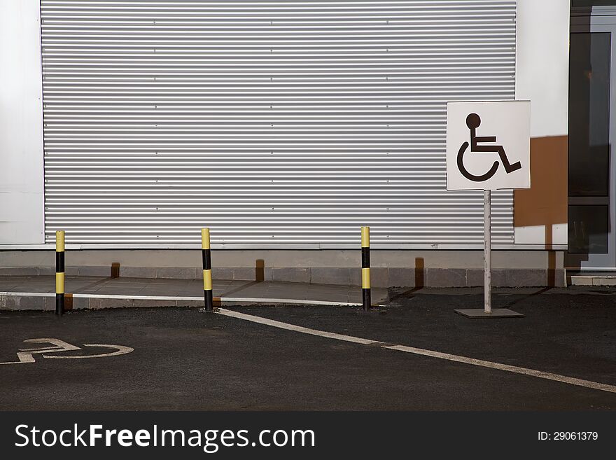 A large handicapped parking sign on a post.