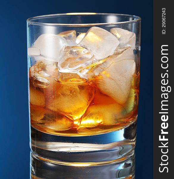 Whiskey glass on a blue background.