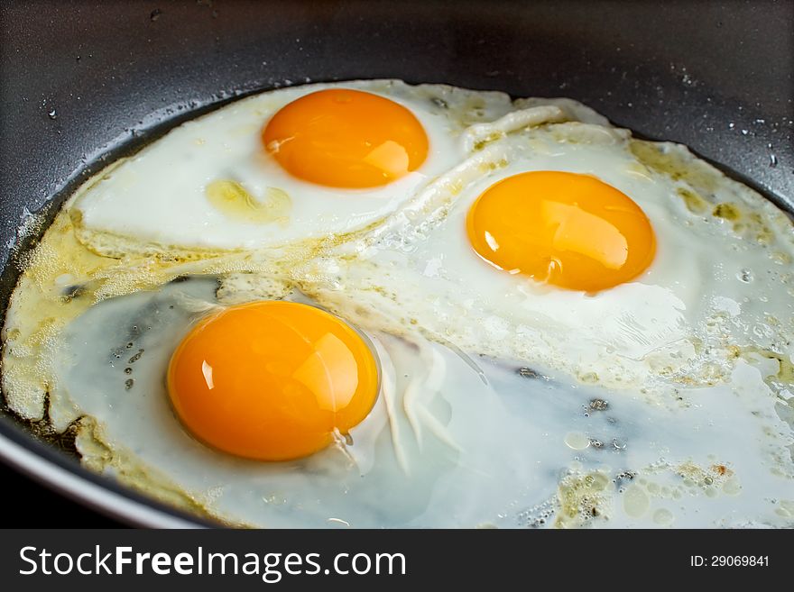Fried eggs in a pan closeup. Fried eggs in a pan closeup