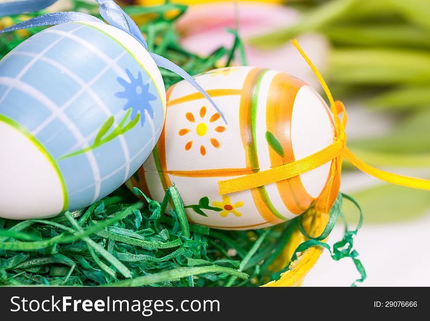 Easter eggs with bows in the basket over floral background