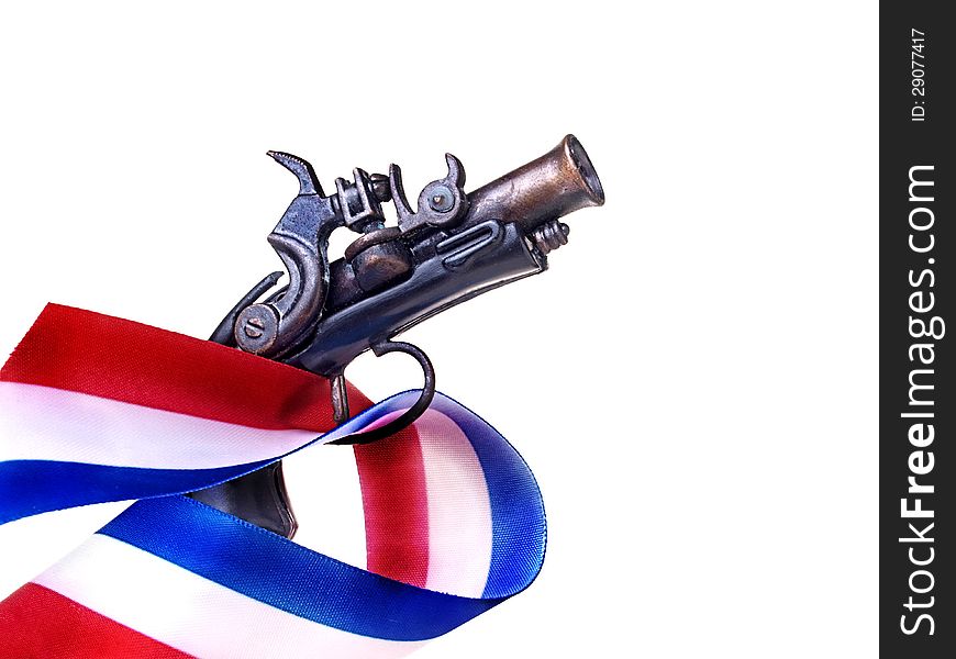 Red white and blue ribbon and antique gun replica. Red white and blue ribbon and antique gun replica.