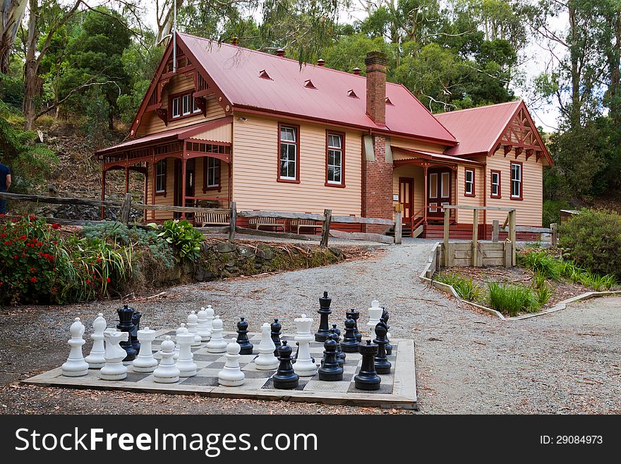 A large chess set sits before a cottage at Coal Creek, Korumburra, Australia. This cottage was formerly a court house in pioneering days. A large chess set sits before a cottage at Coal Creek, Korumburra, Australia. This cottage was formerly a court house in pioneering days.