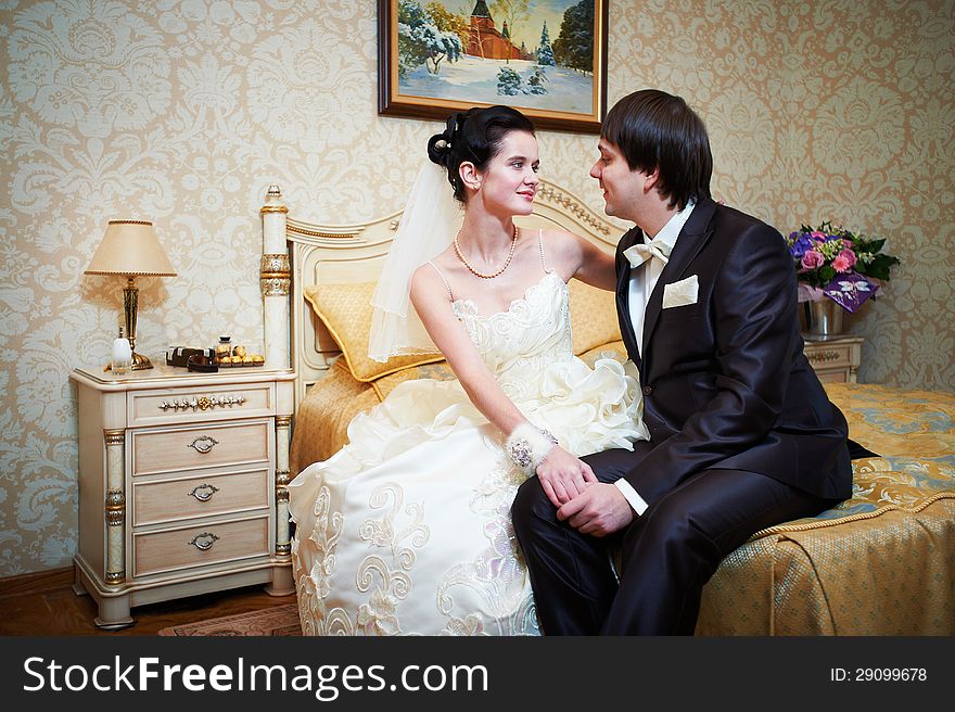 Handsome bride and groom in bedroom on wedding day