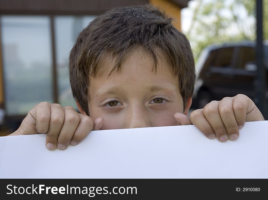 Boy keeps sheet of paper, hands, boat