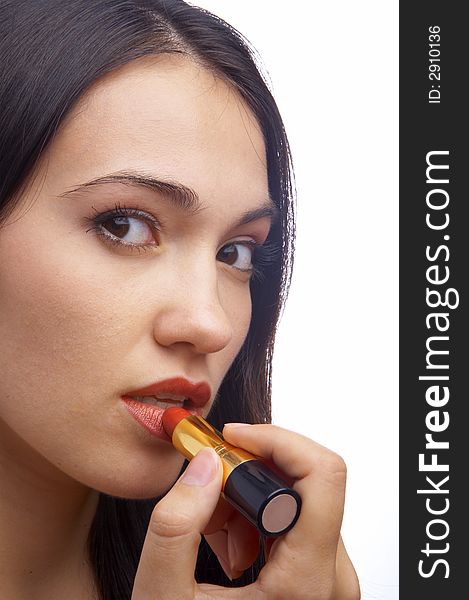 A close-up portrait of a young woman putting on lip liner. A close-up portrait of a young woman putting on lip liner