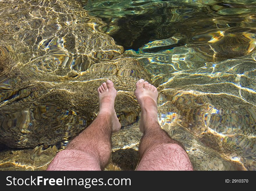 Men legs inside crystal clear water. Men legs inside crystal clear water