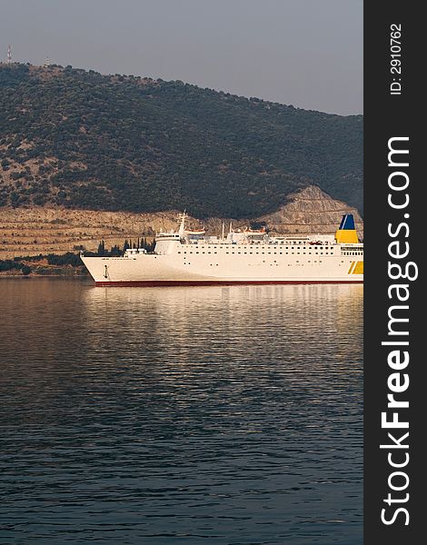 White passenger ship on morning sun near greek shore. White passenger ship on morning sun near greek shore