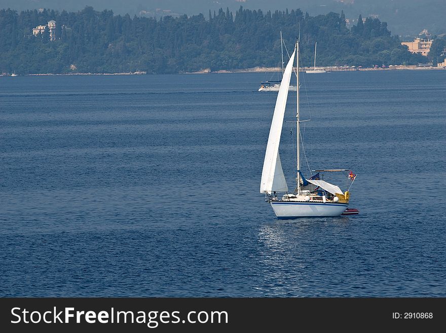 Small yacht sailing on clear blue waters near Corfu Island - Greece. Small yacht sailing on clear blue waters near Corfu Island - Greece