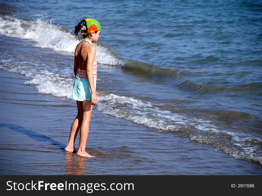 Young girl stand back to audience and look to sea. Young girl stand back to audience and look to sea