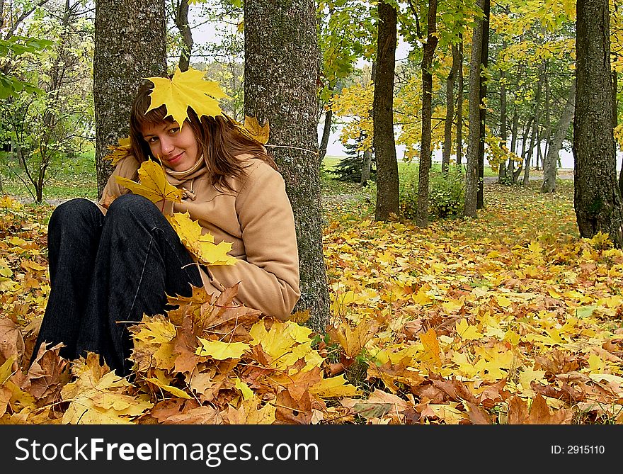 Nice young girl siting in the autumn forest